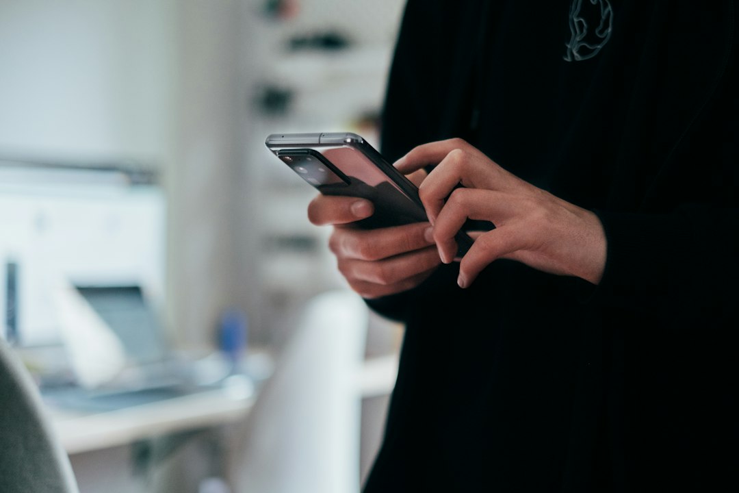 Una persona consulta uno smartphone tenendolo fra le mani.